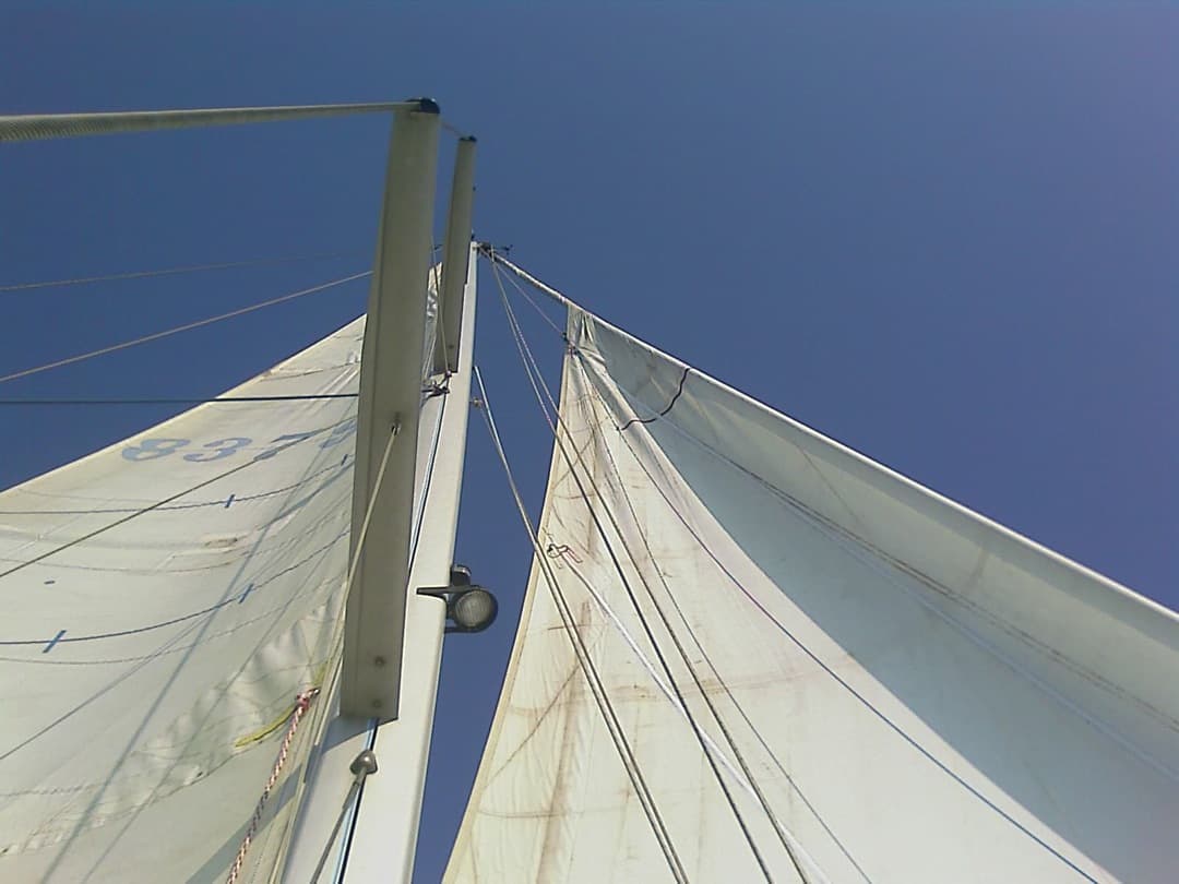 Voiles déployées vues depuis le pont, sous un ciel bleu
